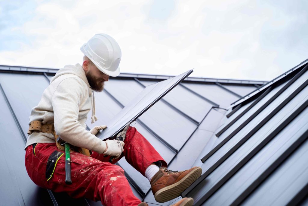 man with helmet ixing leaking roof scaled